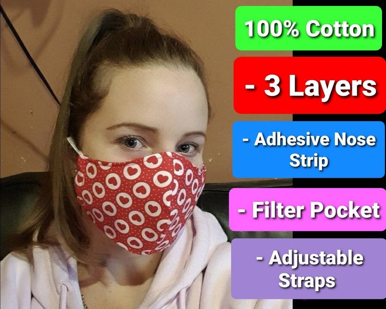 May include: A red face mask with white hearts and circles. The mask is made of 100% cotton and has 3 layers. It also has an adjustable nose strip, a filter pocket, and adjustable straps.