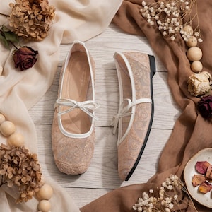 Delicate lace bridal flats with transparent floral mesh and strap styles, minimalist wedding ballet shoes in ivory tones, soft comfortable footwear for bride displayed on neutral fabric background, multiple elegant variations