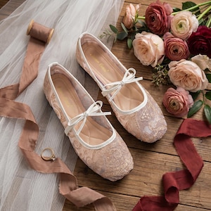 Delicate lace bridal flats with transparent floral mesh and strap styles, minimalist wedding ballet shoes in ivory tones, soft comfortable footwear for bride displayed on neutral fabric background, multiple elegant variations
