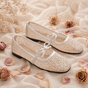 Delicate lace bridal flats with transparent floral mesh and strap styles, minimalist wedding ballet shoes in ivory tones, soft comfortable footwear for bride displayed on neutral fabric background, multiple elegant variations