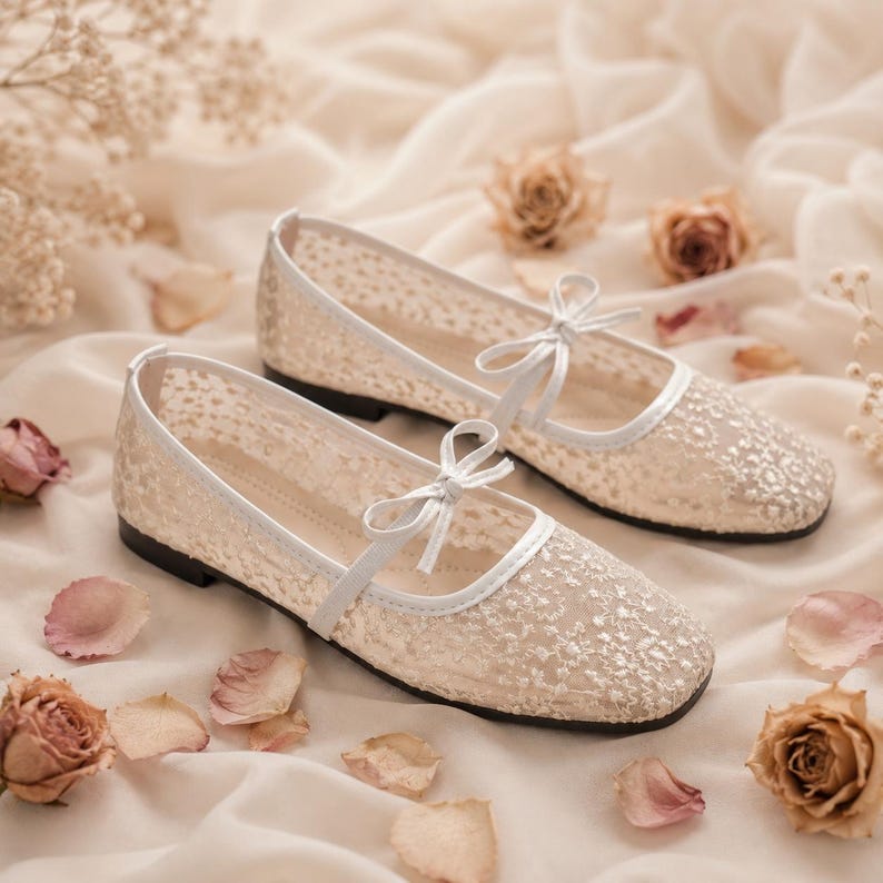 Delicate lace bridal flats with transparent floral mesh and strap styles, minimalist wedding ballet shoes in ivory tones, soft comfortable footwear for bride displayed on neutral fabric background, multiple elegant variations