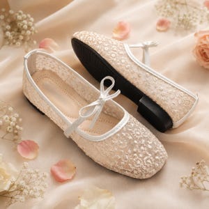 Delicate lace bridal flats with transparent floral mesh and strap styles, minimalist wedding ballet shoes in ivory tones, soft comfortable footwear for bride displayed on neutral fabric background, multiple elegant variations