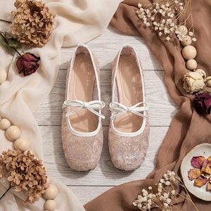 Delicate lace bridal flats with transparent floral mesh and strap styles, minimalist wedding ballet shoes in ivory tones, soft comfortable footwear for bride displayed on neutral fabric background, multiple elegant variations