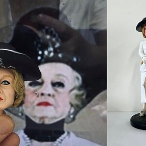 May include: A white ceramic figurine of a woman wearing a white suit, black hat, and holding a white umbrella. The figurine is standing on a black base.