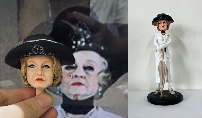 May include: A white ceramic figurine of a woman wearing a white suit, black hat, and holding a white umbrella. The figurine is standing on a black base.