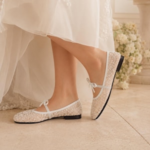 Delicate lace bridal flats with transparent floral mesh and strap styles, minimalist wedding ballet shoes in ivory tones, soft comfortable footwear for bride displayed on neutral fabric background, multiple elegant variations