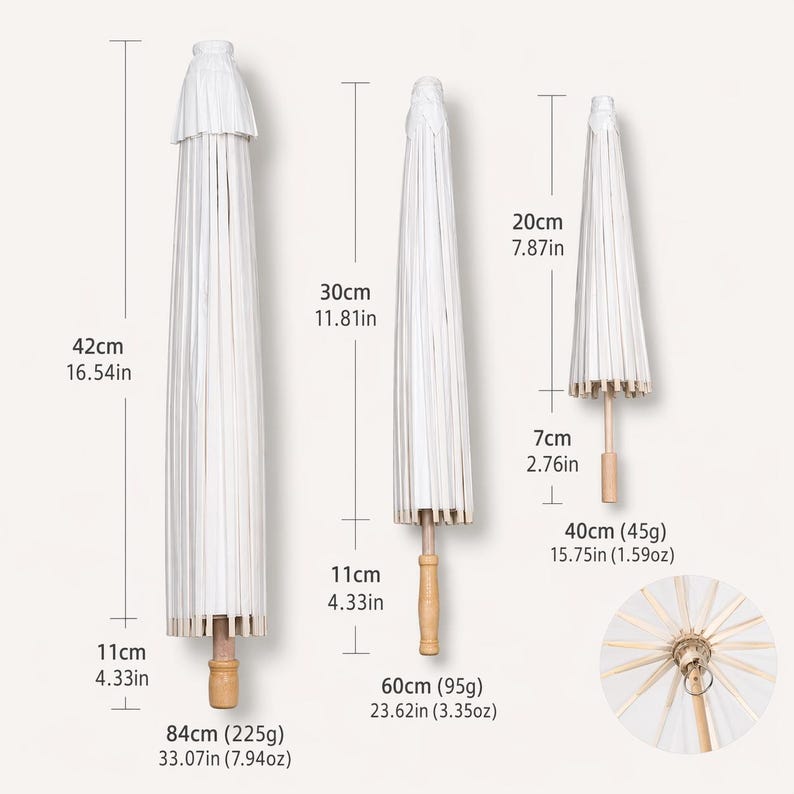 May include: Three white paper parasols of varying sizes are displayed. The largest is 33.07 inches long, the medium is 23.62 inches long, and the smallest is 15.75 inches long. Each has a wooden handle and a decorative top.