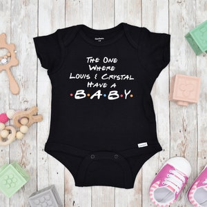 May include: Black baby grow with white text that reads "The One Where Louis & Crystal Have A B.A.B.Y."