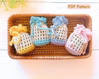 May include: Four handmade crochet drawstring bags in yellow, light blue, lavender, and pink, displayed in a woven basket. The bags have a mesh design and are tied at the top. The text "PDF Pattern" is visible.