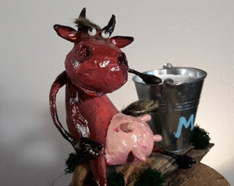 Papier-mâché cow figure with milk, paper-mason cow, funny cow figure, papier-mâché cow figure with a bucket of milk, papier-mâché sitting cow