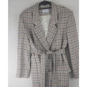 Può includere: Un cappotto vintage a fantasia pied-de-poule nei toni del marrone, beige e nero. Il cappotto presenta un colletto a revers, una vita con cintura e una chiusura con bottoni. Il cappotto è appeso a una gruccia nera.