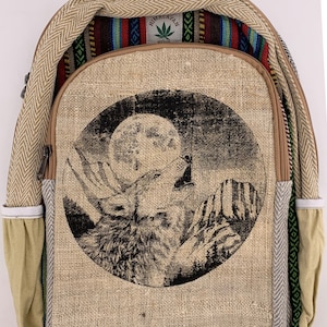 Może przedstawiać: Plecak z konopi z okrągłą grafiką wyjącego wilka pod pełnią księżyca. Plecak wykonany jest z naturalnej tkaniny konopnej z wzorem w jodełkę na górze i kolorowym wzorem w paski wewnątrz. Widoczny jest napis "Himalayan Hemp".