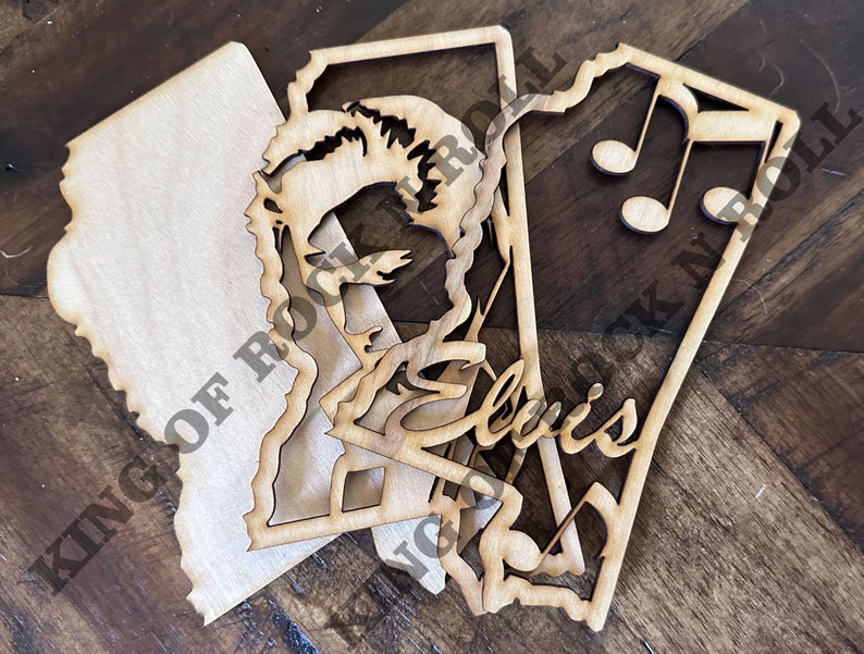 Peut inclure: Trois d&eacute;coupes en bois, l'une avec une silhouette d'Elvis Presley, l'autre avec le texte "King of Rock 'n' Roll", et la derni&egrave;re avec des notes de musique.
