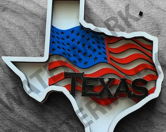 May include: A wooden cutout of the state of Texas with a red, white, and blue American flag design and the word "TEXAS" in black lettering.