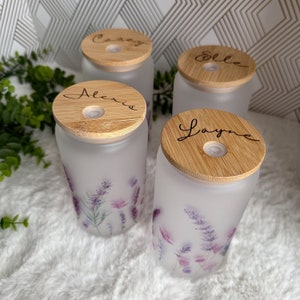 May include: Four frosted glass jars with bamboo lids. Each lid has a different name engraved on it: Casey, Elle, Alexia, and Layne. The jars have a floral design with purple and pink flowers.