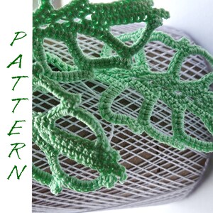 May include: Green crocheted lace with a delicate pattern, laid out on a white mesh surface. The lace is made of fine yarn and has a delicate, airy feel.