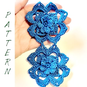 May include: Two crocheted blue flowers connected together. The flowers have a 3D effect and are made with a fine yarn.