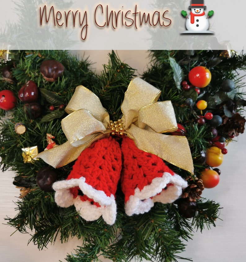 May include: A Christmas wreath with a red and white crocheted bell ornament, a gold bow, and a snowman figurine. The wreath is decorated with green pine branches, red berries, and other festive accents. The text "Merry Christmas" is displayed at the top of the image.