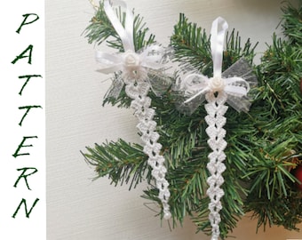 May include: Two white crocheted Christmas ornaments with white bows and white tulle. The ornaments are hanging on a green Christmas tree.