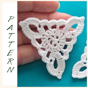 May include: Two white crocheted triangular motifs with a floral design. The motifs are made with delicate stitches and have a lacy appearance.