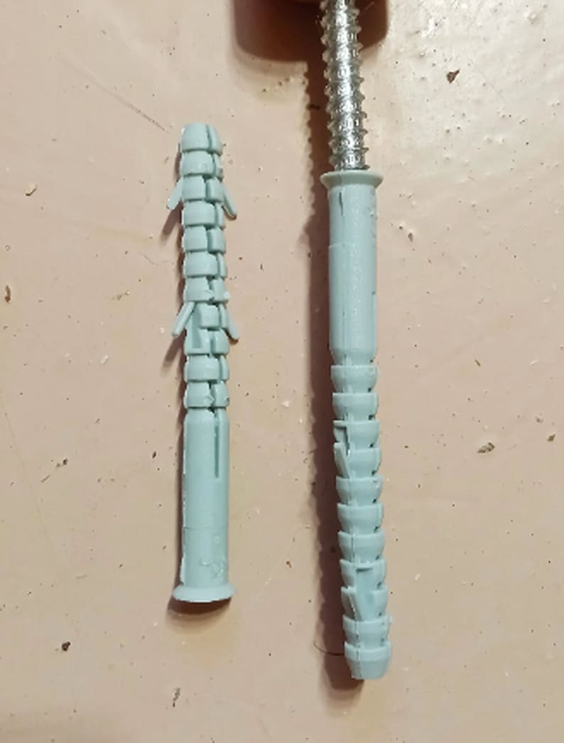 May include: Two plastic wall anchors, one is fully extended and the other is collapsed. Both are light blue in color.