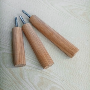 May include: Three wooden dowels with metal screws at the top. The dowels are different lengths and are arranged in a triangular shape.