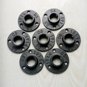 May include: Eight black metal pipe flanges with the text "1914" and "DS" printed on them. The flanges have a hole in the centre and four holes around the edge.