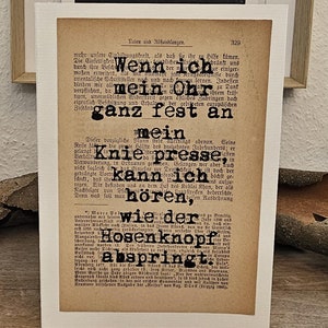 Könnte beinhalten: Eine Karte im Vintage-Stil mit einem schwarz-weißen Textausschnitt aus einem Buch. Der Text lautet "Wenn ich mein Ohr ganz fest an mein Knie presse, kann ich hören, wie der Hosenknopf abspringt."
