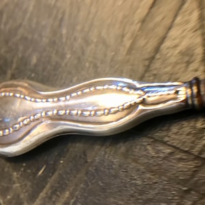 Peut inclure: Une cuillère de service en argent plaqué avec un manche décoratif. Le manche est en forme de larme et a un bord perlé.