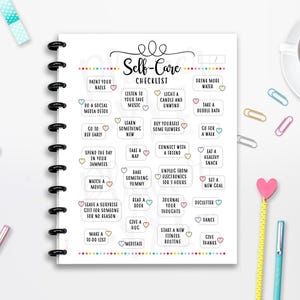 May include: A spiral-bound self-care checklist with a variety of self-care activities listed. The checklist includes tasks like "Paint Your Nails," "Go for a Walk," and "Journal Your Thoughts." A cup of tea and stationery items are also visible.