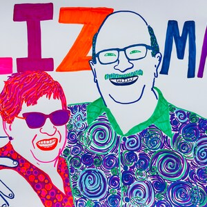 Op de afbeelding: Een kleurrijke illustratie van een stel, Liz en Marc, met een draaiend patroon op het shirt van de man. De vrouw draagt een zonnebril en een shirt met stippen. De namen Liz en Marc staan in grote, kleurrijke letters boven hen.