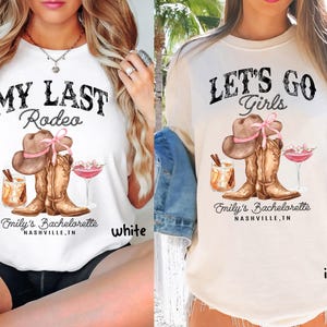 May include: White and ivory t-shirts with a graphic design featuring a cowboy hat, boots, and cocktails. The text on the shirts reads "MY LAST Rodeo" and "LET'S GO Girls". The shirts are for Emily's Bachelorette in Nashville, TN.