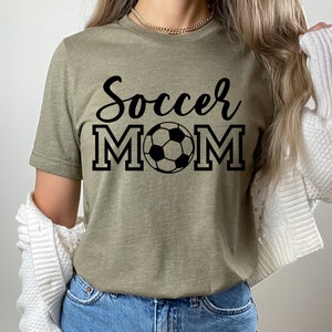 May include: A green t-shirt with the text "Soccer Mom" in black lettering and a black and white soccer ball graphic.