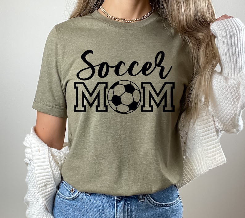 May include: A green t-shirt with the text "Soccer Mom" in black lettering and a black and white soccer ball graphic.