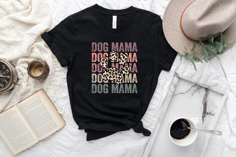 May include: Black t-shirt with the text "DOG MAMA" repeated five times in a vintage style with a leopard print paw print in the center.