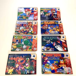 May include: A collection of eight Nintendo 64 game cartridges, including Super Mario 64, Mario Kart 64, Paper Mario, Super Smash Bros, Yoshi's Story, Star Fox 64, Banjo-Kazooie, and Diddy Kong Racing. The cartridges are arranged in two rows of four, with the titles facing the viewer.