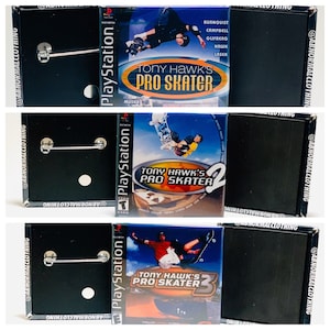 May include: Three black square pinback buttons with images of the video game Tony Hawk's Pro Skater 1, 2, and 3. Each button features the PlayStation logo and the game's title.