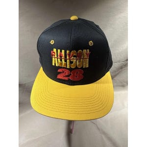 May include: A black and yellow baseball cap featuring the name "Allison" embroidered in gold and the number "28" in red. The cap has a flat peak and a yellow button on top.