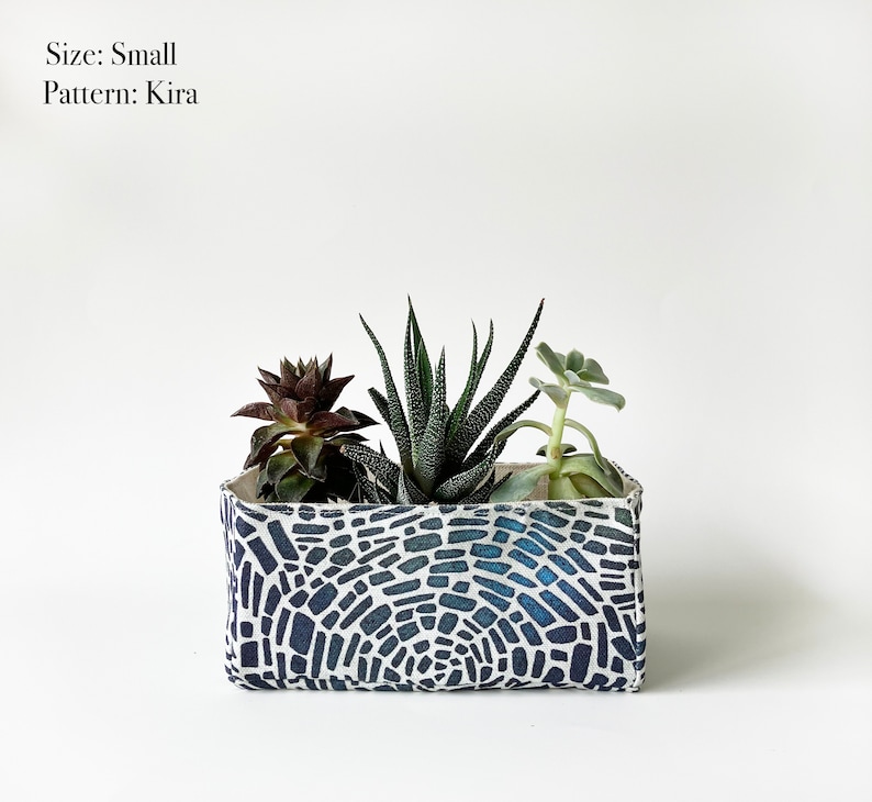 May include: A small rectangular planter with a blue and white mosaic pattern, filled with three succulents. The text "Size: Small" and "Pattern: Kira" is visible.