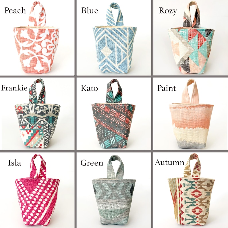 May include: Nine fabric doorstops in various colours and patterns. The doorstops have a handle at the top. Colours include peach, blue, rozy, frankie, kato, paint, isla, green, and autumn. Each doorstop has a unique design.