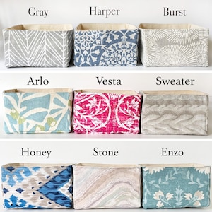 May include: Nine fabric storage bins in various patterns and colors. The bins are labeled with names like "Gray", "Harper", "Burst", "Arlo", "Vesta", "Sweater", "Honey", "Stone", and "Enzo". Each bin has a neutral-colored interior.