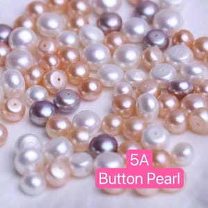 May include: A collection of 5A button pearls in various shades of white, pink, and lavender. The pearls are smooth and round, and they are arranged in a random pattern. The text "5A Button Pearl" is written in pink letters on a white background.