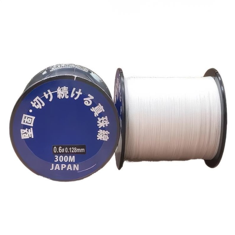 Może przedstawiać: Szpula białej żyłki wędkarskiej z niebiesko-białą etykietą z napisem "0.6# 0.128mm 300M JAPONIA". Etykieta zawiera r&oacute;wnież tekst japoński.