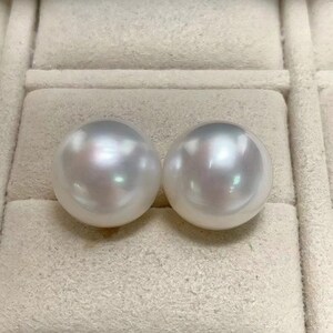 Puede incluir: Dos perlas redondas blancas en una caja de terciopelo blanco. Las perlas son lisas y brillantes.