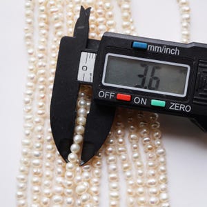 May include: A close-up of a digital caliper measuring a strand of white pearls. The caliper reads 3.6 mm.