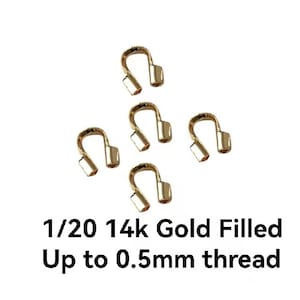 Puede incluir: Cinco cierres de joyería en forma de U rellenos de oro. El texto en la imagen dice "1/20 14k Gold Filled Up to 0.5mm thread". Estos cierres están diseñados para la fabricación de joyas y manualidades.