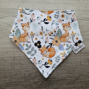 Puede incluir: Un bandana blanco con un patr&oacute;n de zorro y flores. El bandana tiene un esquema de color azul claro, amarillo, naranja y negro. El texto "Mini Nous" est&aacute; impreso en el bandana.