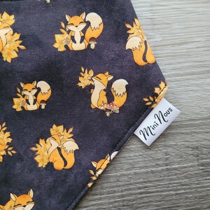 Puede incluir: Un bandana negro con un patr&oacute;n repetido de zorros naranjas y hojas de oto&ntilde;o. El bandana tiene una etiqueta blanca que dice "Mini Nous".