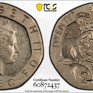 May include: A silver 2001 twenty pence coin. The obverse features a profile of Queen Elizabeth II, surrounded by text. The reverse shows a crown above a Tudor rose, with the denomination and year. The coin is graded by PCGS.