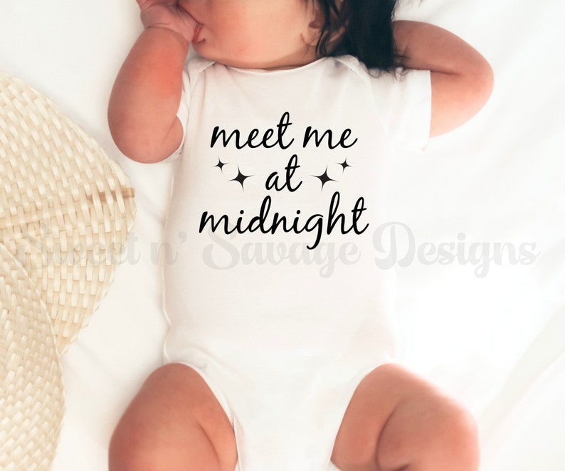 May include: White baby onesie with black text that reads "meet me at midnight" with two small stars on either side of the word "at".